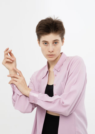 Stylish fashion woman model with short haircut in pink shirt posing on white background.の写真素材