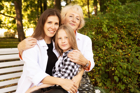 Lifestyle and people concept. Grandmother With Granddaughter And Mother In Autumn Park. Happy family.の写真素材
