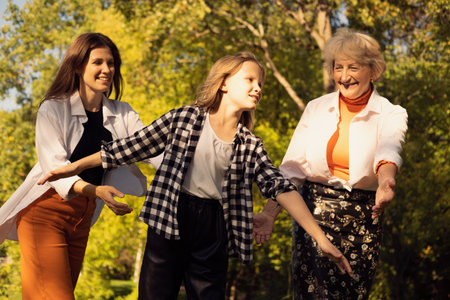 Lifestyle and people concept. Grandmother With Granddaughter And Mother In Autumn Park. Happy family.の写真素材