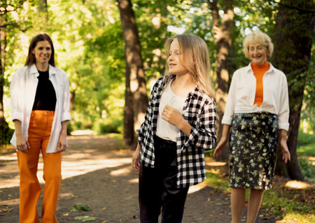 Lifestyle and people concept. Grandmother With Granddaughter And Mother In Autumn Park. Happy family.の写真素材