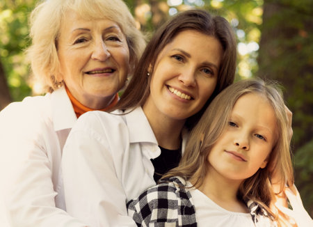 Lifestyle and people concept. Grandmother With Granddaughter And Mother In Autumn Park. Happy family.の写真素材