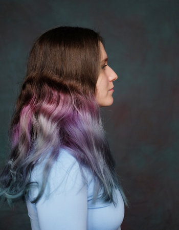 Profile of young woman with stylish wavy colored hair. Close-up portrait, side view.の写真素材