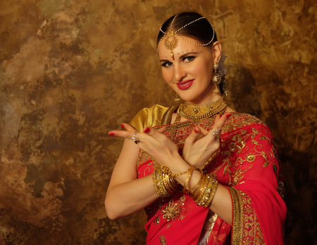 Beautiful indian woman dancer in red sari.の写真素材