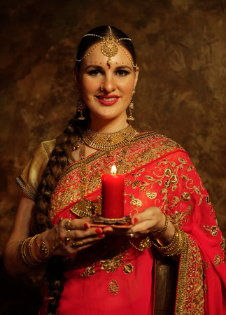 Charming young woman holding a candle.の写真素材