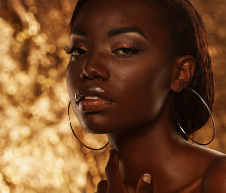 portrait of beautiful african woman with creative gold make upの写真素材