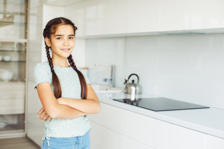 Charming smiling ten-year-old girl with pigtails, close-up portrait at home.の写真素材