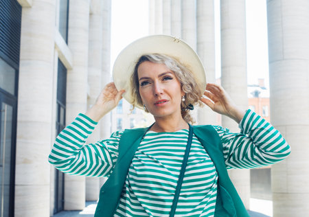 Blond Woman Outdoor Portrait. Green outfit with hat. Fashion trend of summer or spring.の写真素材