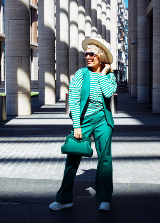 Blond Woman Outdoor Portrait. Green outfit with hat. Fashion trend of summer or spring.の写真素材