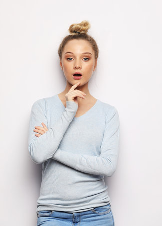 surprised young woman over white studio backgroundの写真素材