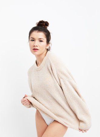 lifestyle, fashion and people concept: beautiful woman wearing casual beige sweaterの写真素材