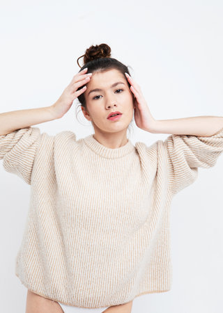lifestyle, fashion and people concept: beautiful woman wearing casual beige sweaterの写真素材