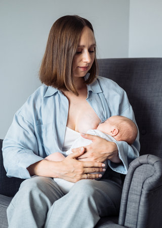 Loving mom caring of her newborn baby at home. Family concept.の写真素材
