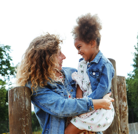 A beautiful young mother plays with her daughter in a park near the beach. Having fun and feeling happy.の写真素材