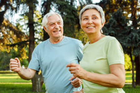 Smiling senior couple jogging in the parkの写真素材