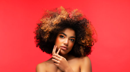 Portrait of Young African female model with a beautiful makeup over red background. Close up portrait.の写真素材