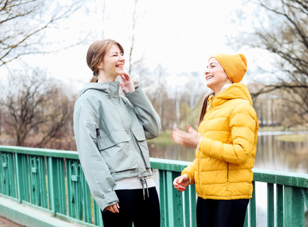 Two young athletic women friends in a spring park.
