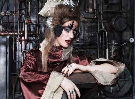 Steampunk woman with bright make up in a creative interior. Art and fashion concept.の写真素材