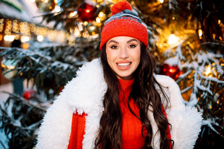 Young woman at the Christmas market next to the New Year tree.の写真素材