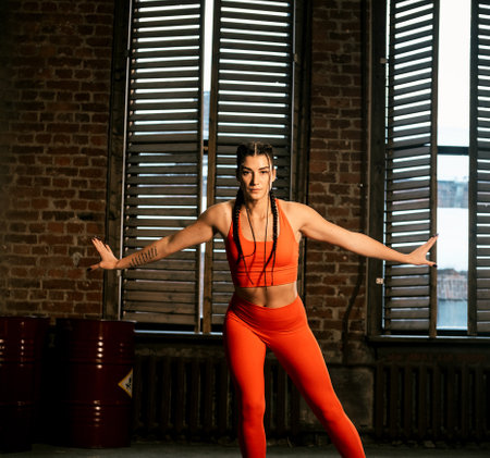 Strong young woman in activewear jumping in a cardio workout at the gym.の写真素材