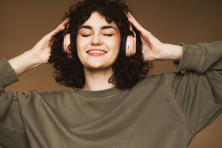 lifestyle and people concept: young woman in headphones listening to music smiling with closed eyesの写真素材