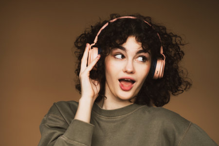 lifestyle and people concept: young woman in headphones listening to music smiling and dancing.