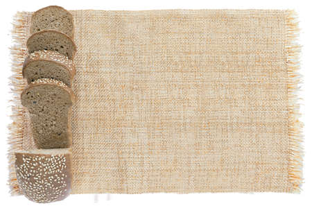 Sliced fresh bread on sackcloth isolated on white background.  Bread slices viewed from above. Top view with space for your textの写真素材