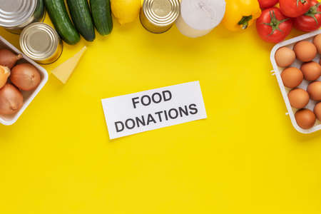 Food donations on yellow background. Food help . Top view with copy spaceの写真素材