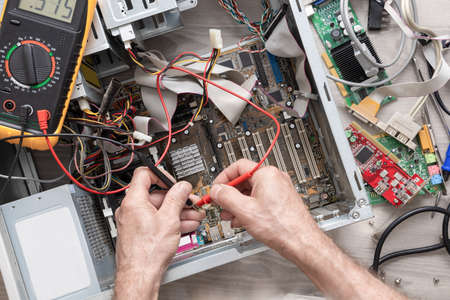 Computer assembly. Multimeter test. Computer diagnostics. Hands of the master are checking the...