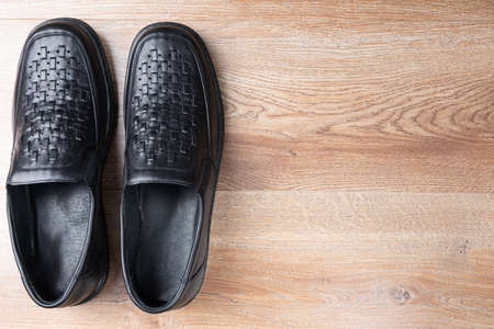 New black men shoes on wooden background. Elastic sided shoes. Side gusset shoes. Lazyman shoes. Top view. Copy spaceの写真素材