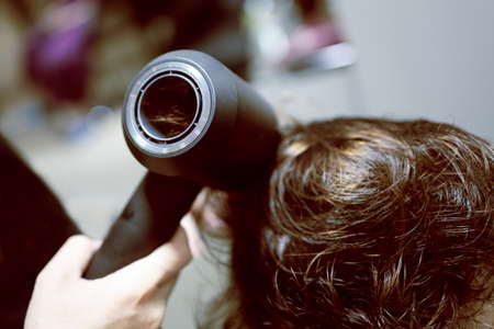 Hairdressing services during coronavirus. Hairdresser in face mask cuts hair of woman in face mask. Hairdressers cutting hair during COVID-19の写真素材
