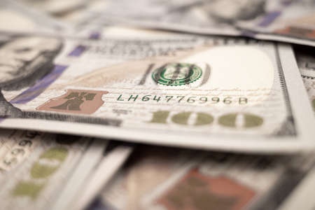 Pile of dollars lies on the table. One hundred dollar bills dumps on table. Background for design...