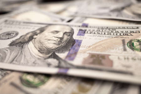 Pile of dollars lies on the table. One hundred dollar bills dumps on table. Background for design...