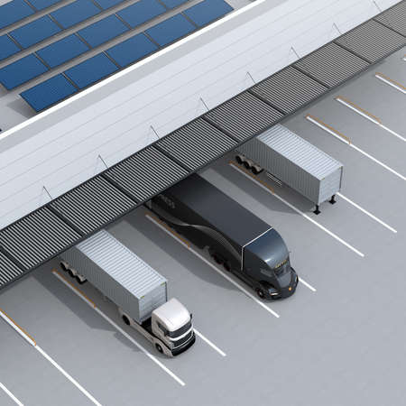 Top view of electric trucks parking in front of modern logistics center. Solar panels mounted on the...