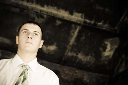 young businessman looking far away, desaturated toned photo, copy space for the textの写真素材