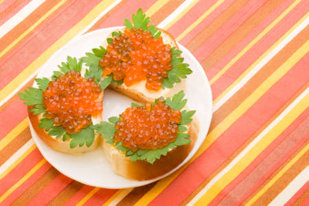 sandwiches with butter green parsley and red salmon caviar on the plate