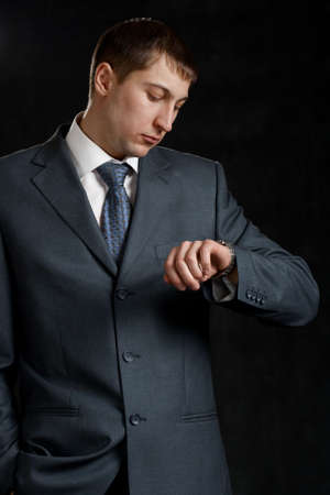 businessman looking to watch on blackの写真素材