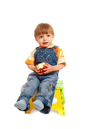 boy with apple sitting on chair isolated on whiteの写真素材