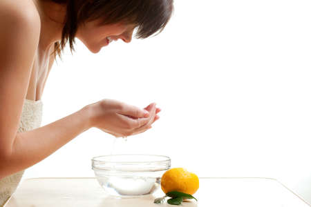 woman washing her face over whiteの写真素材