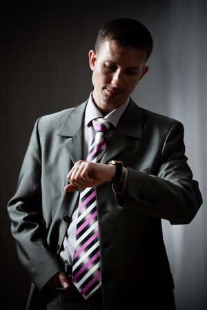 businessman looking at watch over darkの写真素材