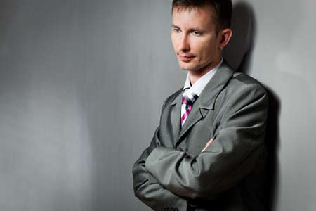 thinking businessman portrait near  gray wallの写真素材