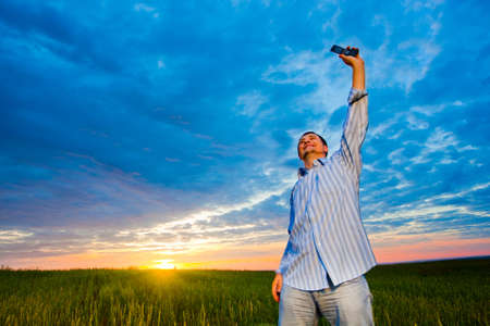 man with cell phone on field
