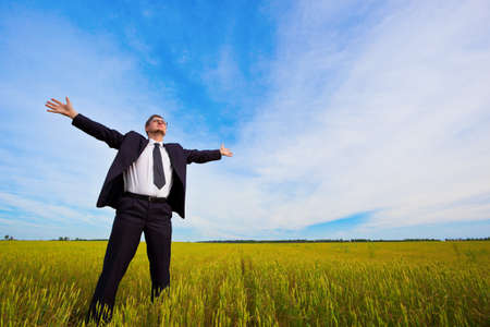 businessman on yellow field under blue skiesの写真素材