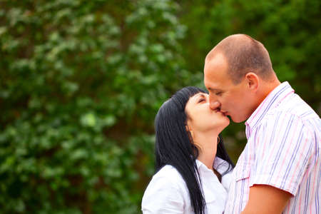 young lovely couple kissing in the parkの写真素材
