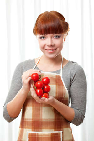 ginger woman wearing apron with tomatoesの写真素材