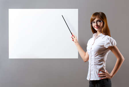 smiling woman showing with pointer to blank placardの写真素材