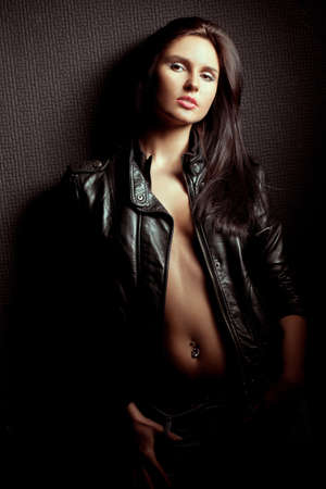 beautiful sexual  woman portrait wearing leather jacket near wallの写真素材