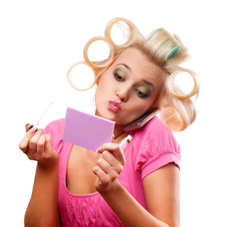 funny blonde woman with rollers on head over whiteの写真素材