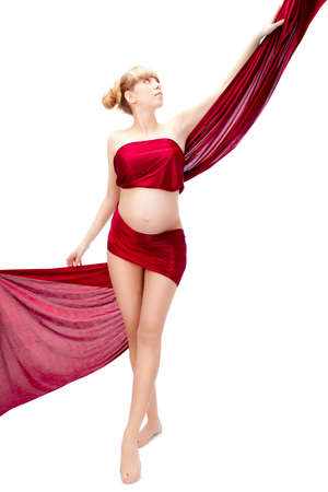 isolated pregnant woman enveloped to red textileの写真素材