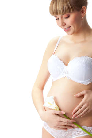 closeup pregnant woman abdomen with white flowerの写真素材