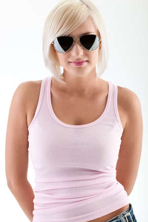 blonde woman fashion portrait wearing sunglasses and pink tank topの写真素材